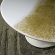 Tavolo ovale in legno laccato con piano in resina bianca e trasparente con foglia oro in immersione.